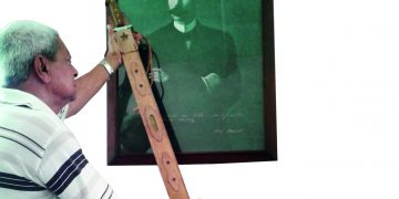 Javier muestra la Réplica del Machete Mambí del Generalísimo Máximo Gómez, junto a un cuadro de Martí