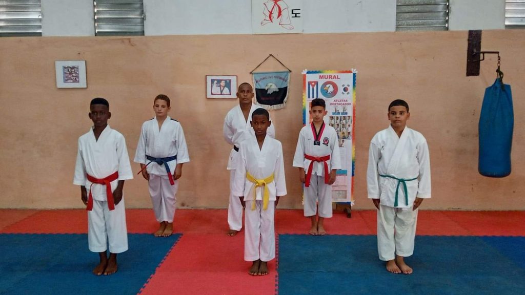 Los niños medallistas junto a su entrenador José Yusney Scull. Foto tomada del canal de Telegram de los Halcones@tkdhalconescuba